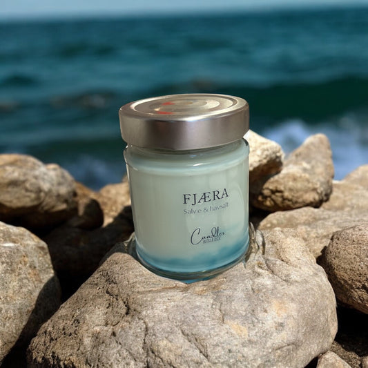 Glassbeholder med sølvlokk, inneholder duftlys med teal farge