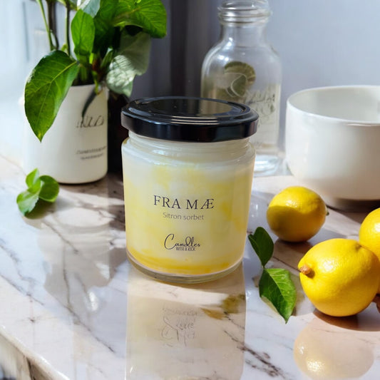 Glassbeholder med svart lokk, inneholder duftlys med gul farge