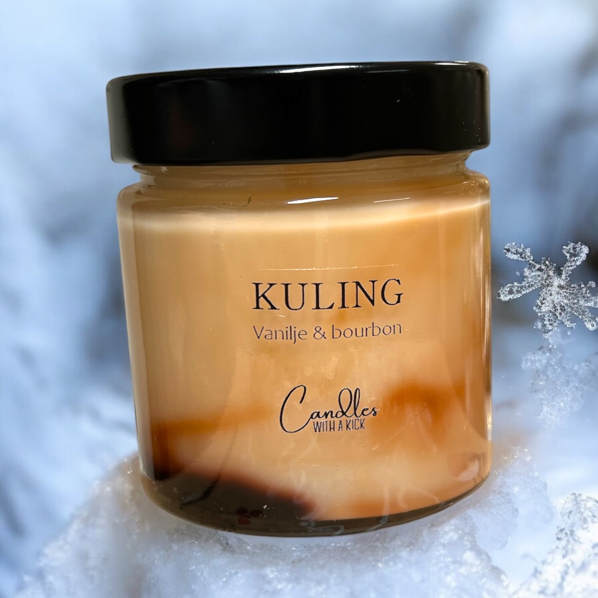 Glassbeholder med svart lokk, inneholder duftlys med brun farge